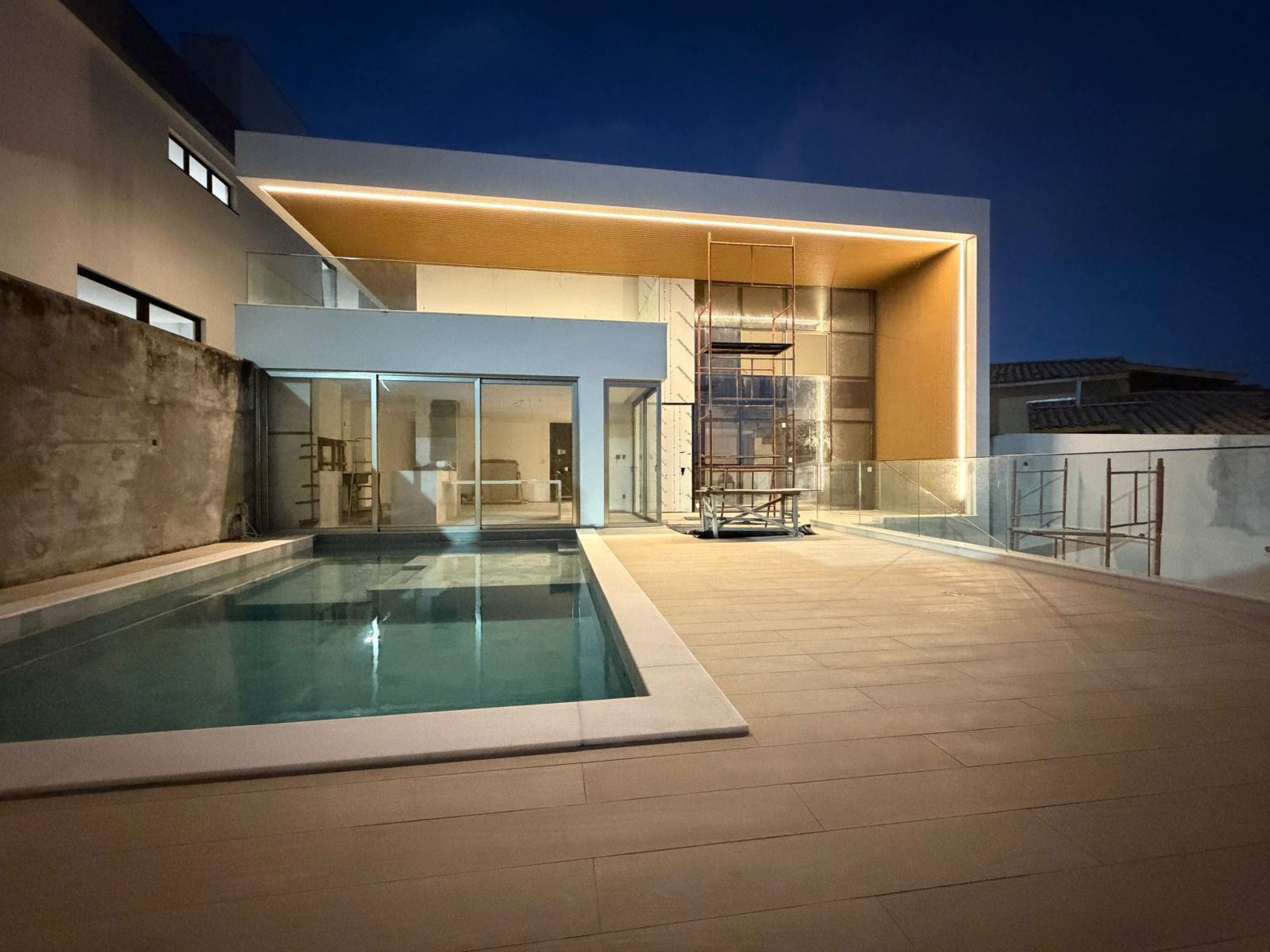 Casa em obra com iluminação em LED embutida no forro de madeira e piscina, projeto de automação em Salvador